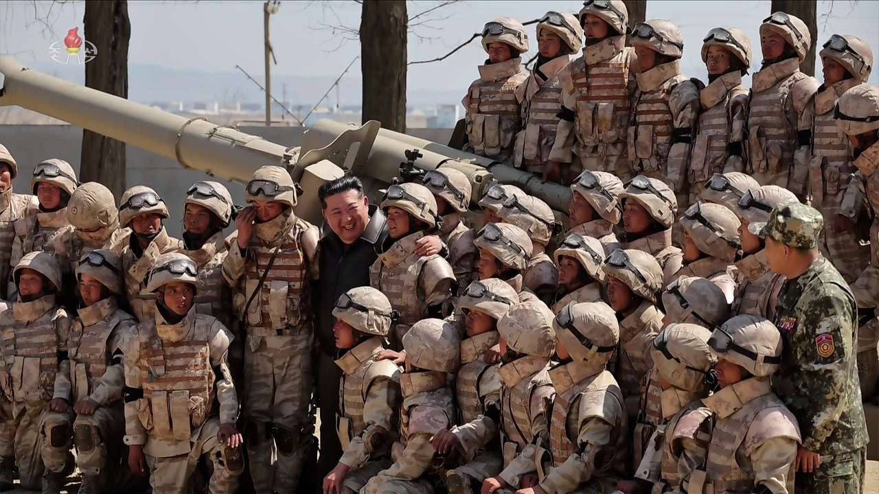 North Korean leader Kim Jong-un poses for a photo with soldiers from an artillery unit of the Korean People’s Army after observing a live-fire drill on April 15. (Korean Central TV via Yonhap)