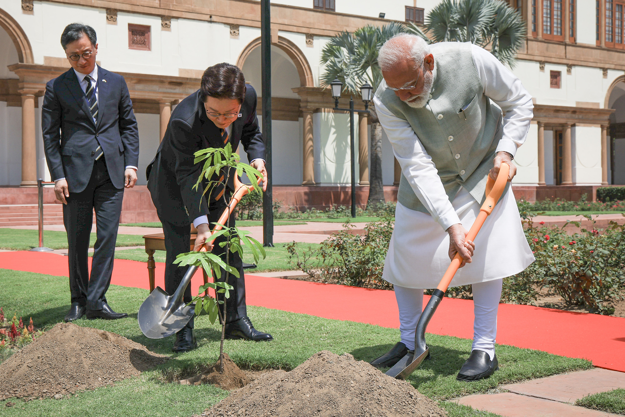 President Lee Jae Myung and Indian Prime Minister Narendra Modi take part in a commemorative tree-planting ceremony ahead of their summit at the state guest house in New Delhi on Monday. (Yonhap)