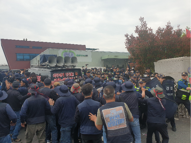Members of the Korean Public Service and Transport Union are being blocked by police during a protest in front of the BGF Retail's logistics center in Jinju, South Gyeongsang Province, Monday. (Yonhap)
