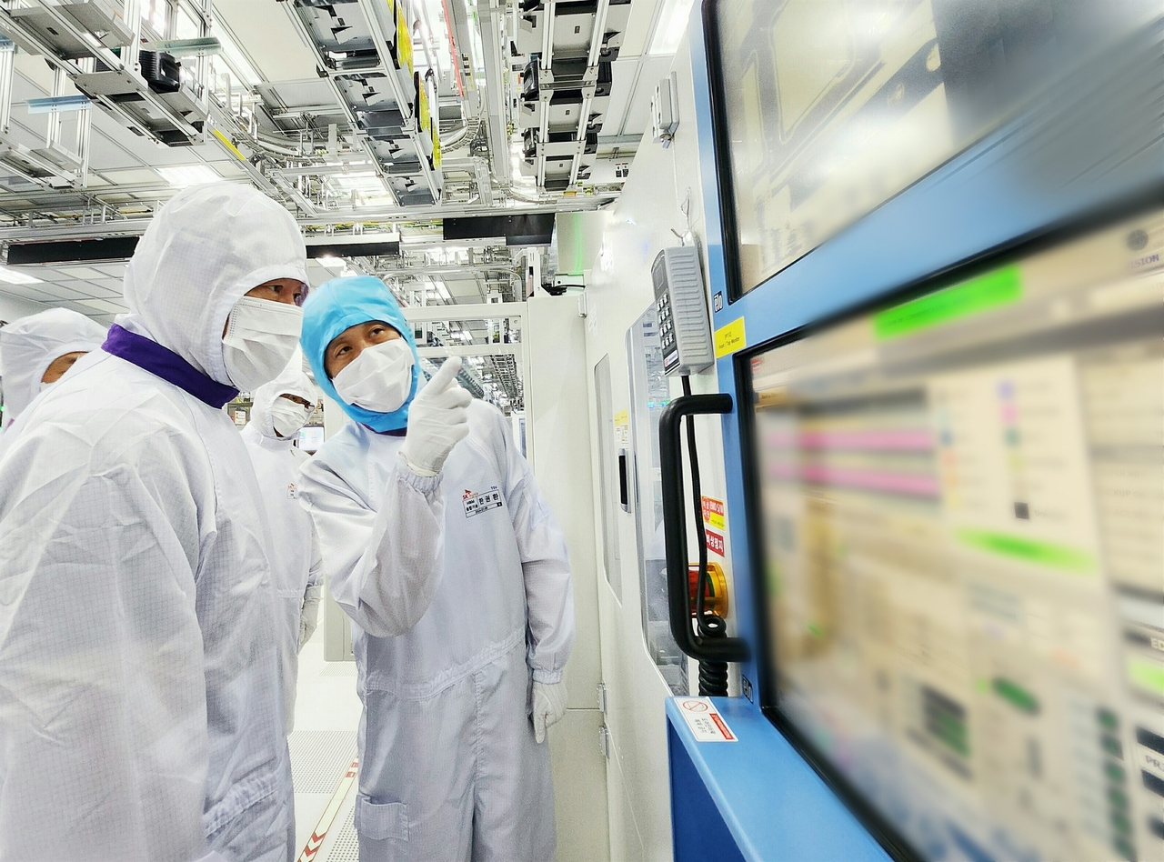 SK Group Chairman Chey Tae-won (left) reviews manufacturing equipment at SK hynix's HBM facility in Icheon, Gyeonggi Province, in August 2024. (SK hynix)