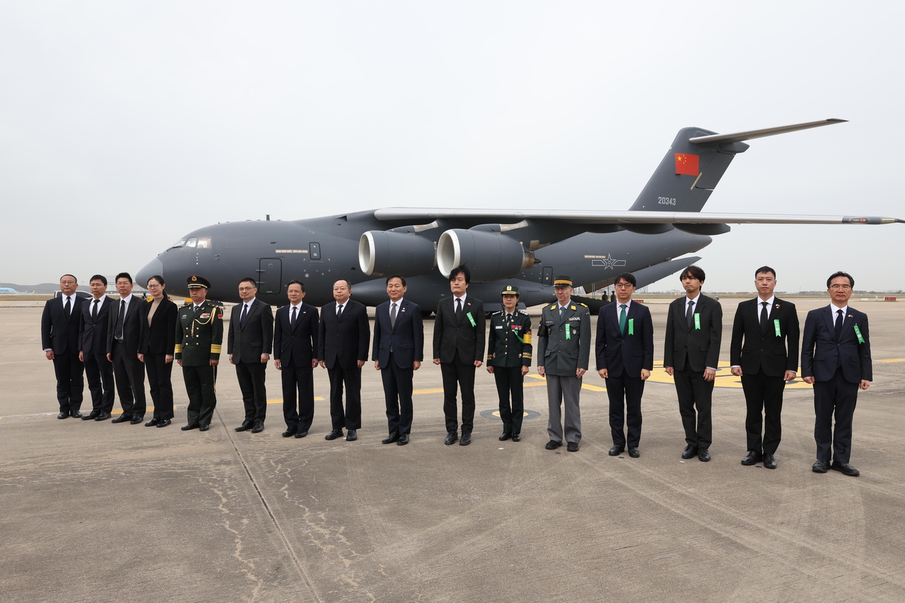 South Korean Vice Defense Minister Lee Doo-hee (ninth from left), Xu Yao (eighth from left), vice minister of China’s Ministry of Veterans Affairs, and Chinese Ambassador to South Korea Dai Bing (seventh from left) pose for a photo with officials from both countries during the 13th repatriation ceremony of Chinese soldiers’ remains at Incheon Airport on Wednesday. (Defense Ministry)