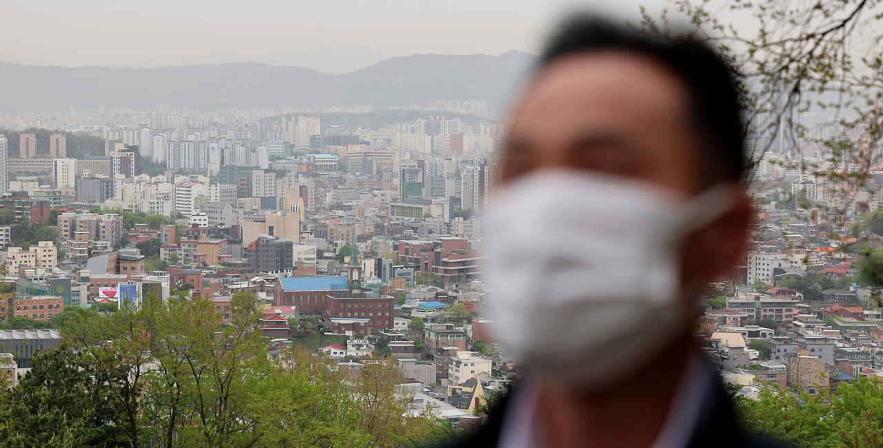 A man walks wearing a mask on Wednesday morning, as fine dust levels remain elevated. (Yonhap)