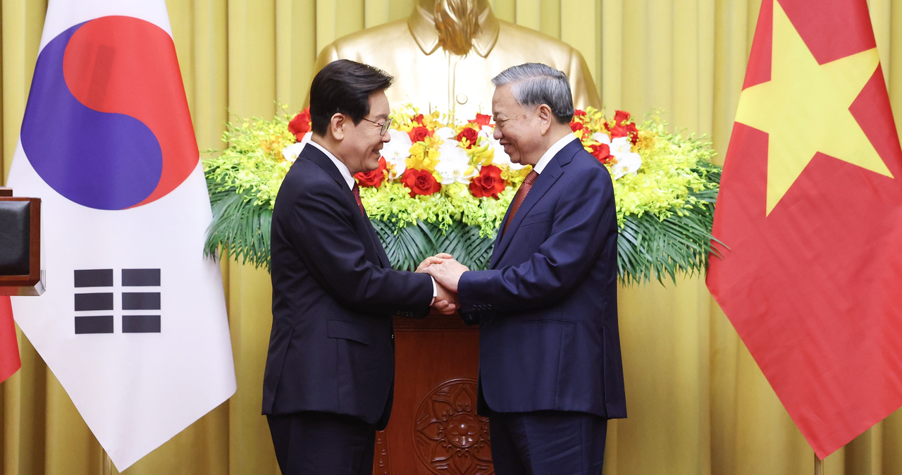South Korean President Lee Jae Myung (left) and Vietnamese President To Lam, who also serves as general secretary of the Communist Party of Vietnam, shake hands after delivering joint press remarks at the Presidential Palace in Hanoi on Wednesday. (Yonhap)