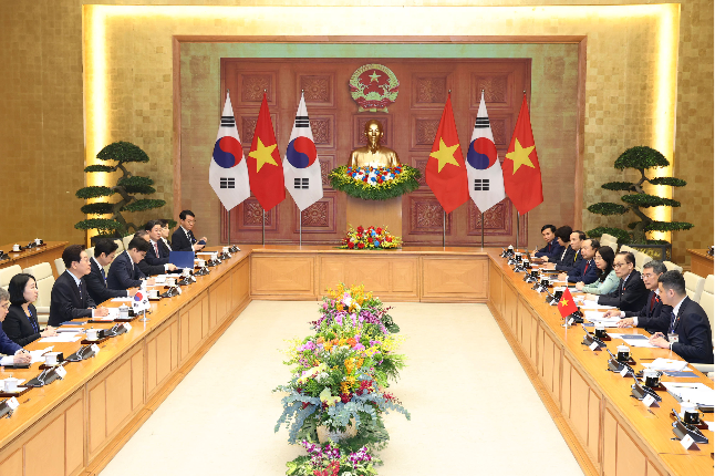 President Lee Jae Myung talks with Prime Minister Le Minh Hung at the Prime Minister’s Office in Hanoi on Thursday during his state visit to Vietnam. (Yonhap)