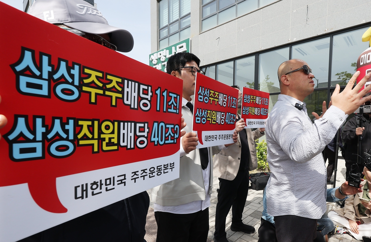 Samsung Electronics shareholders protest the union's bonus demands near the company's Pyeongtaek campus, holding placards questioning employee bonus vs. shareholder dividends.