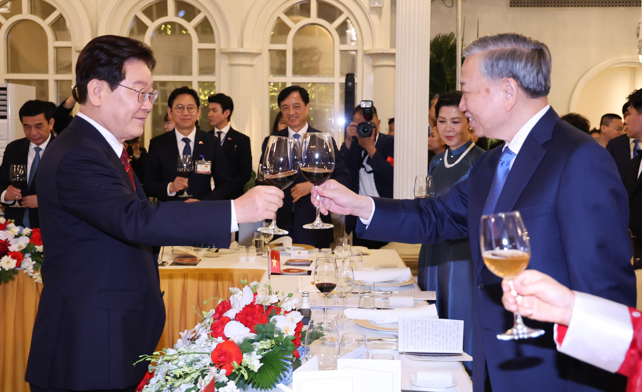 President Lee Jae Myung and To Lam, General Secretary of the Communist Party of Vietnam and President of Vietnam, raise a toast during a state banquet welcoming Lee’s state visit at the International Convention Center in Hanoi on Wednesday. (Yonhap)