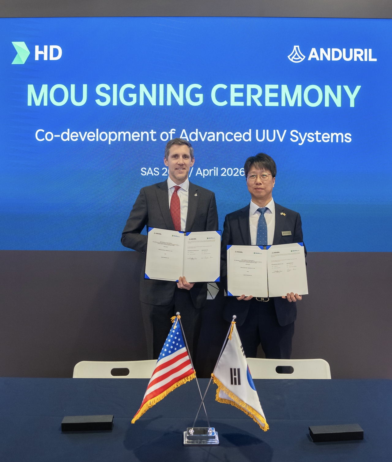 Lee Sang-bong (right), senior vice president of HD Hyundai Heavy Industries’ naval and special ship business unit, and Andrew Nuss, head of Anduril Industries’ maritime division, pose for a photo after signing a memorandum of understanding on Wednesday at SAS 2026 in Washington. (HD Hyundai)