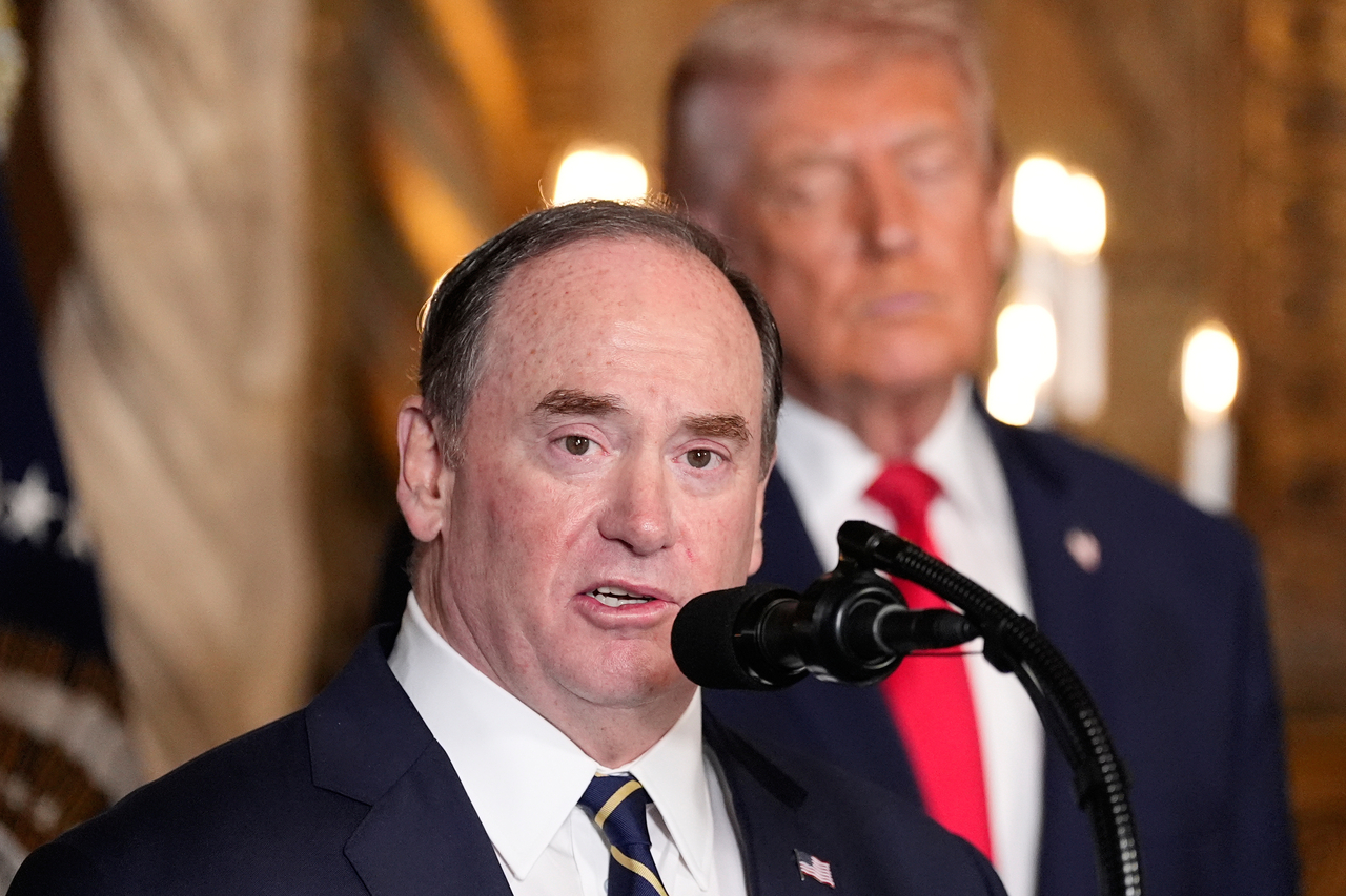 US Secretary of the Navy John Phelan (front) speaks, as President Donald Trump listens in Palm Beach, Florida, in December 2025. (AP-Yonhap)