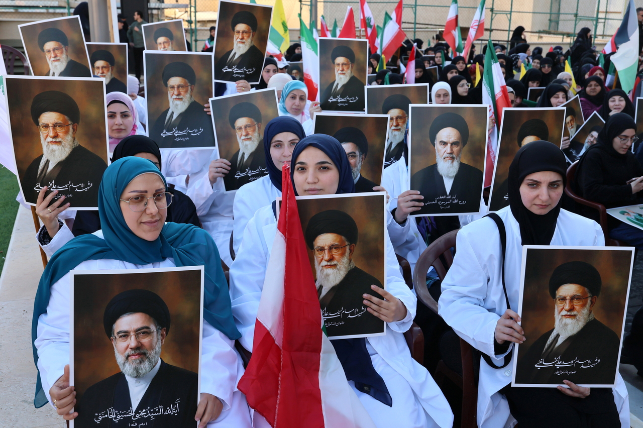 Medical staff and Hezbollah supporters hold portraits of Ali Khamenei and his successor, Mojtaba Khamenei, during a commemorative rally for the slain Iranian Supreme Leader Ali Khamenei in Beirut, Wednesday. (EPA-Yonhap)