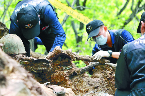 Service members excavate human remains believed to be from soldiers killed during the Korean War at a Defense Ministry recovery site. (Ministry of National Defense)