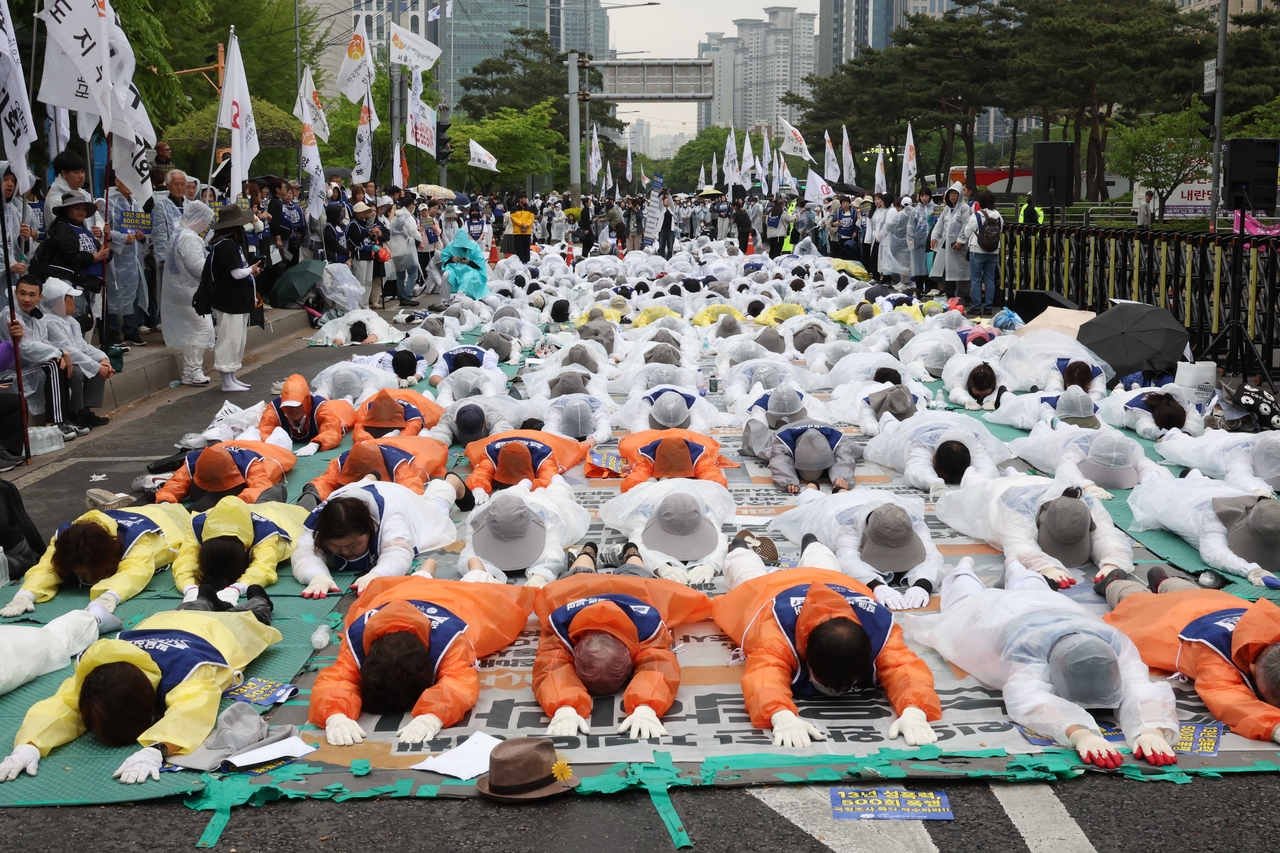 Members of the Korean Parents' Network for the People with Disabilities hold a “full-body prostration” protest in front of the National Assembly in central Seoul on Monday. (Newsis)