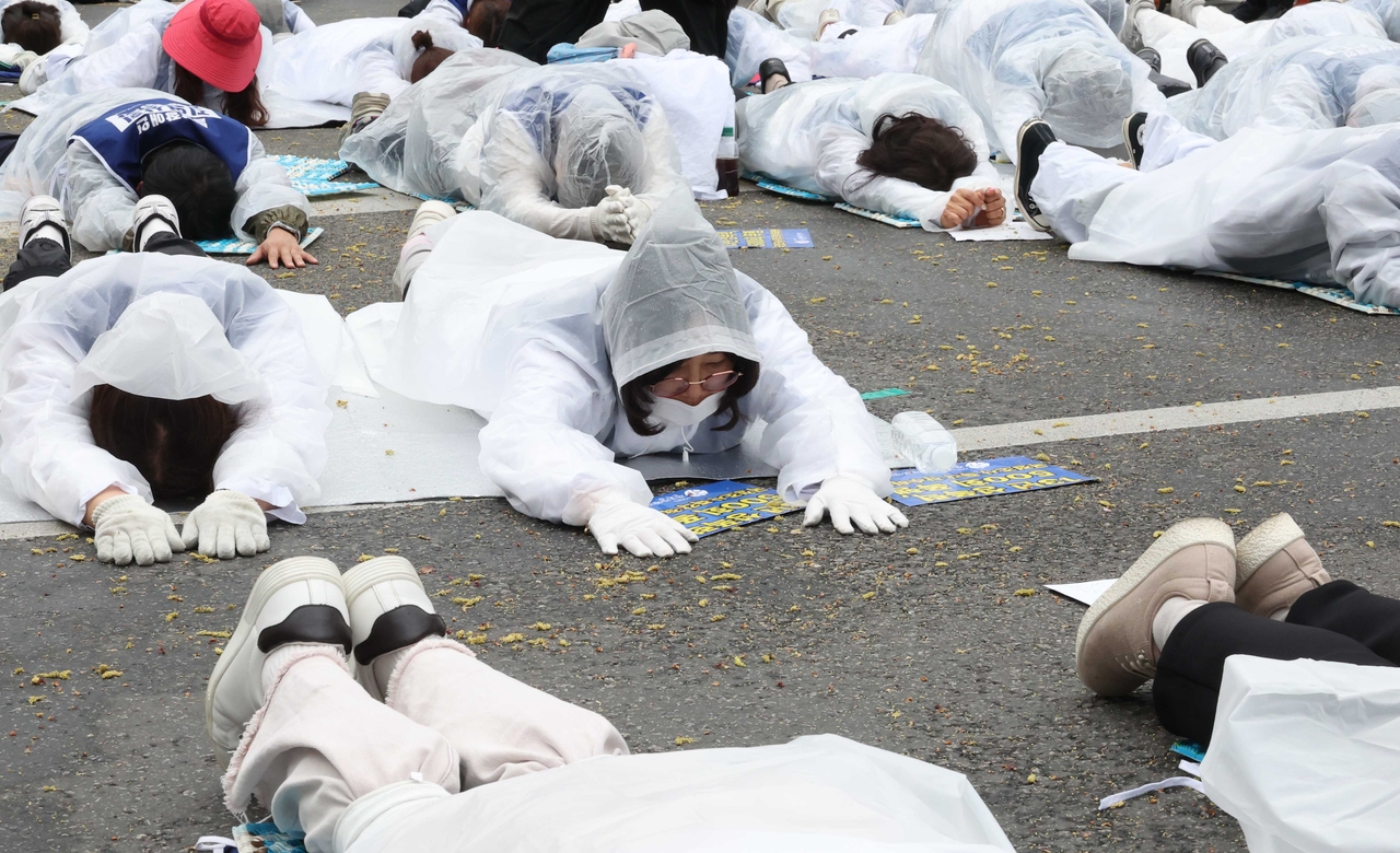Members of the Korean Parents' Network for the People with Disabilities hold a “full-body prostration” protest in front of the National Assembly in central Seoul on Monday. (Newsis)