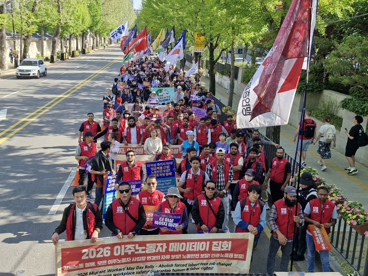 Participants in a rally for migrant workers’ rights in Korea march toward Cheong Wa Dae in central Seoul on Sunday. (KCTU)