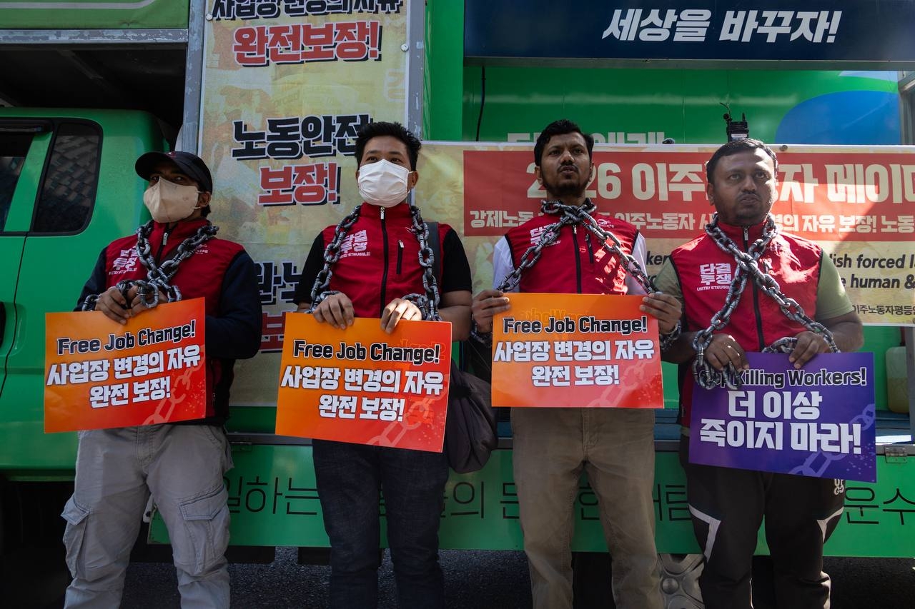 Participants in a rally for migrant workers’ rights perform a protest against visa restrictions on job changes during a rally in central Seoul on Sunday. (KCTU)
