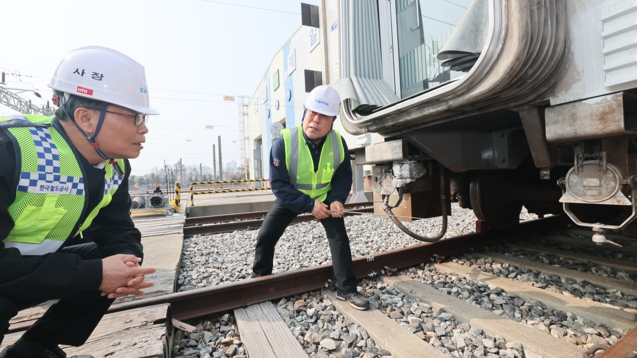 Korail CEO Kim Tae-seung (left) inspects parts of an electric multiple unit coupler on March 27 in Siheung, Gyeonggi Province. (Yonhap)