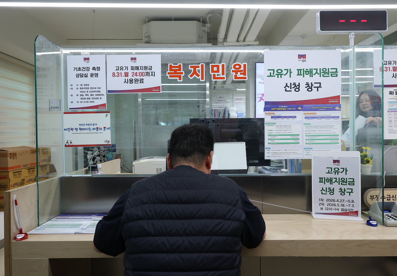 A citizen fills out a cash aid application form at a community service center in Jongno-gu, Seoul, on Monday. (Yonhap)