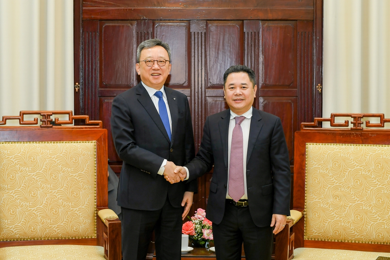 Jung Sang-hyuk (left), CEO of Shinhan Bank, and Nguyen Ngoc Canh, deputy gov. of the State Bank of Vietnam, pose for a photo after a meeting at the central bank in Hanoi, Vietnam, Wednesday. (Shinhan Bank)