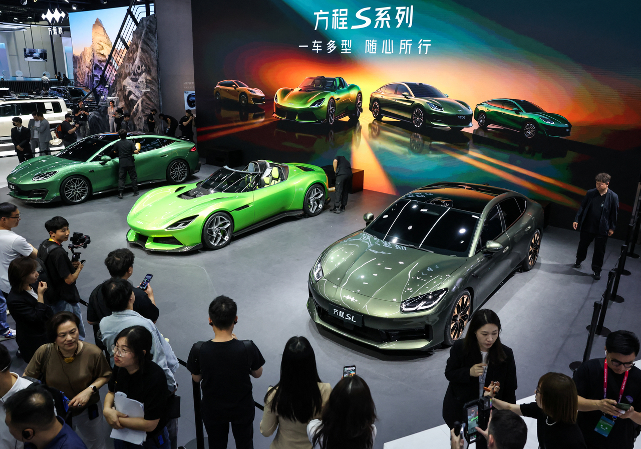 People gather near the newly presented electric cars, Formula S, Formula X, and Formula SL of BYD's brand Fang Cheng Bao appear at the company's booth at Auto China in Beijing on Friday. (Reuters-)