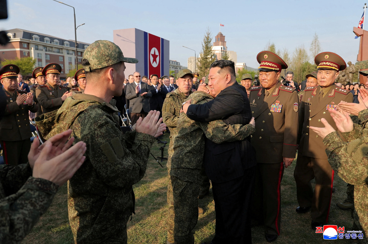 North Korean leader Kim Jong-un (center) hugs a trooper deployed to Russia during a ceremony marking the completion of a war memorial for overseas military operations in Pyongyang on Sunday. (KCNA via Yonhap)