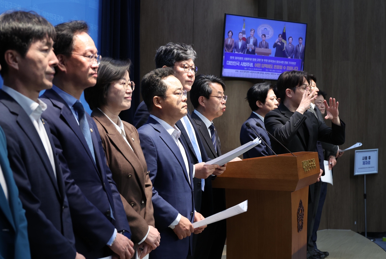 Rep. Park Hong-bae (sixth from left) of the Democratic Party of Korea and other liberal lawmakers hold a press conference at the National Assembly on Tuesday. (Newsis)