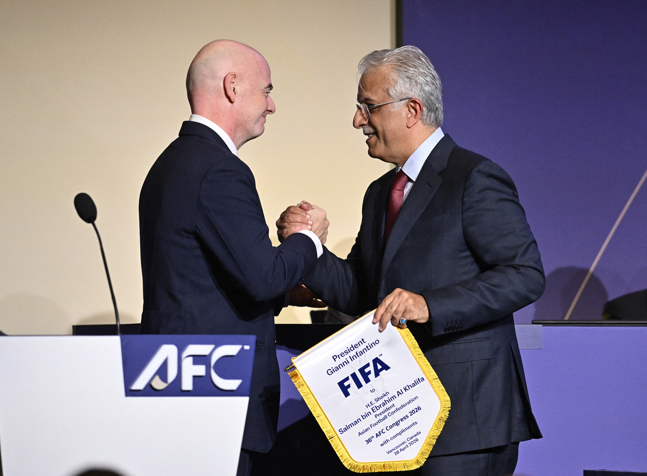FIFA president Gianni Infantino (left) shakes hands with Senior Vice-President of the FIFA Council, Salman bin Ibrahim Al Khalifa, in Vancouver, British Columbia, Tuesday.    (Reuters-Yonhap)