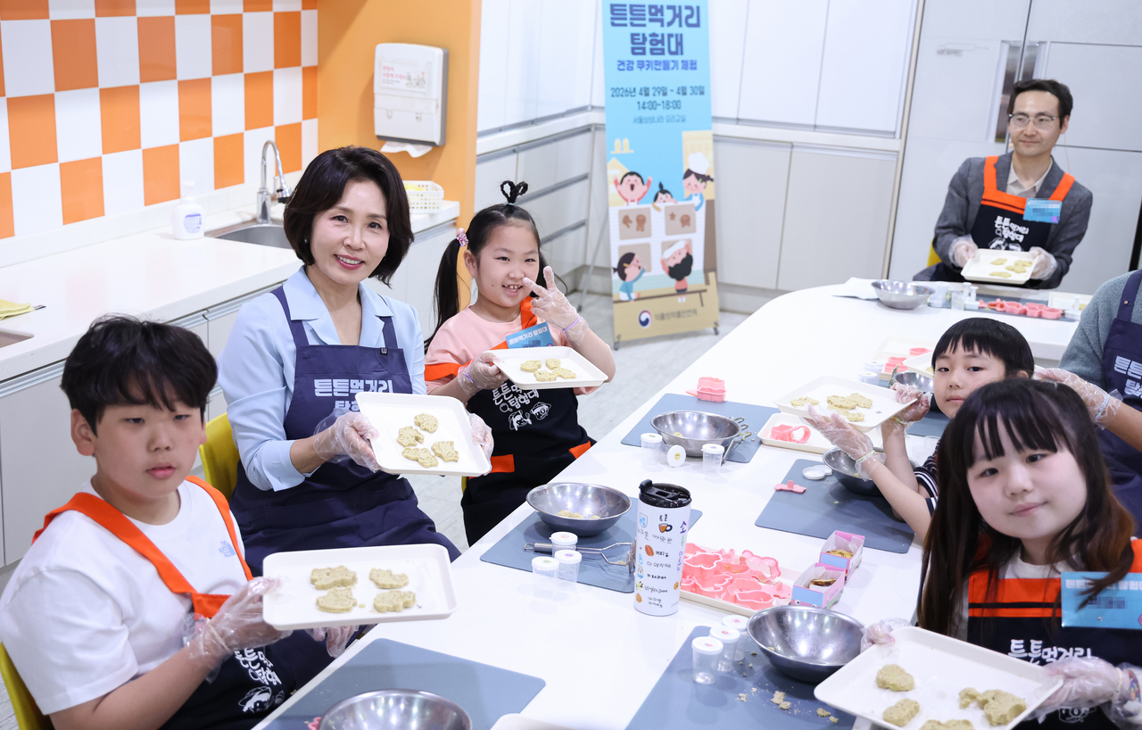 First lady Kim Hea Kyung holds up “hope cookies” she made with children living with glycogen storage disease at Seoul Children’s Museum in Seoul Children’s Grand Park in Gwangjin-gu, Seoul, on Wednesday. (Pool Photo via Yonhap)