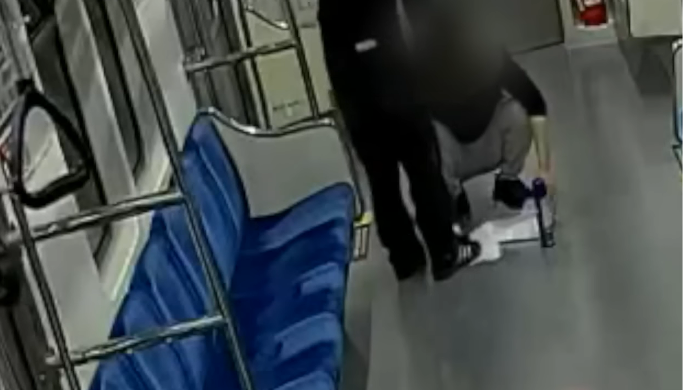 Moon Song-hak (left) stamps out a piece of paper that the suspect had set fire to on Daegu's subway Line 1 on April 23. (Screen capture from SBS news report)