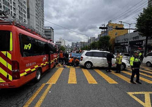 Firefighters in Incheon respond after a van hit an apartment complex security guard on Tuesday. (Incheon Fire Department)