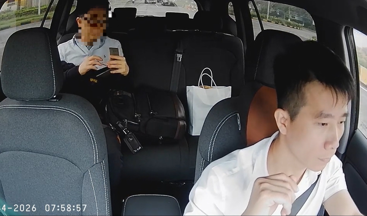 A screenshot from a video shows a Korean passenger in the back handing pocket money to a taxi driver’s young daughter in a taxi in Hanoi, Vietnam. (TikTok @dangvandan22)