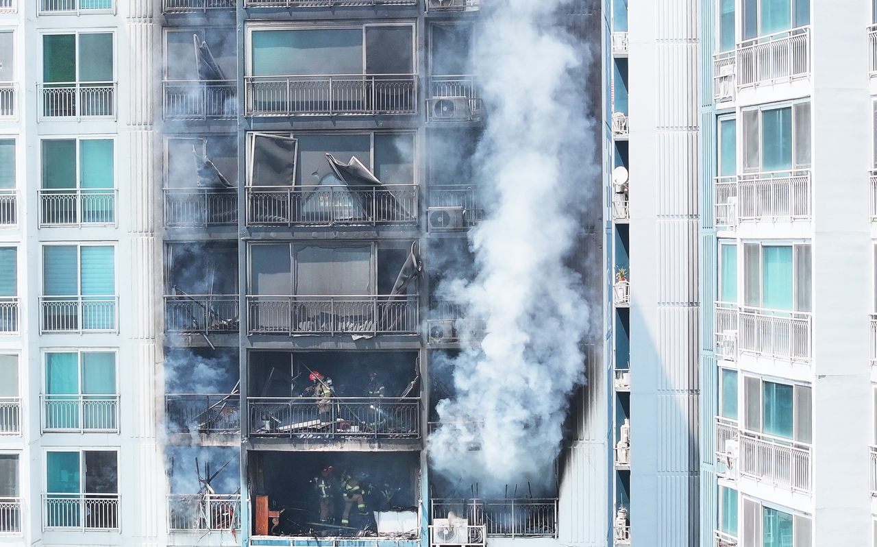 Firefighters work at an apartment building where a fire broke out in Uiwang, Gyeonggi Province, on Thursday. (Yonhap)