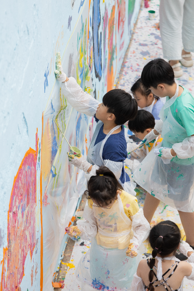 Children paint a wall with their hands.  (Seoul Foundation for Arts and Culture)
