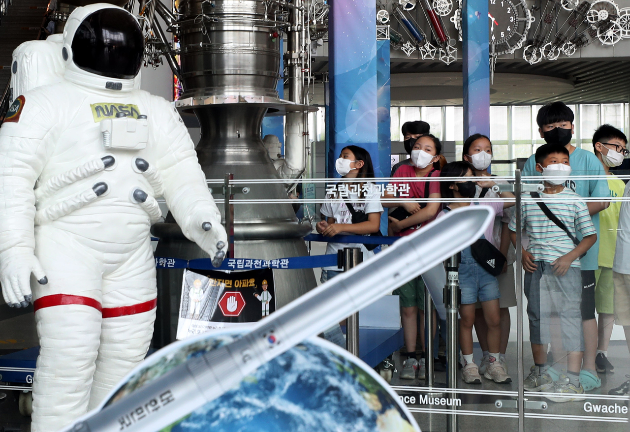 Students from an elementary school look at the first-stage engine of the Nuri rocket at a special exhibition marking the launch of South Korea’s homegrown space launch vehicle at the National Gwacheon Science Museum in Gwacheon, Gyeonggi Province, June 22, 2022. (Newsis)