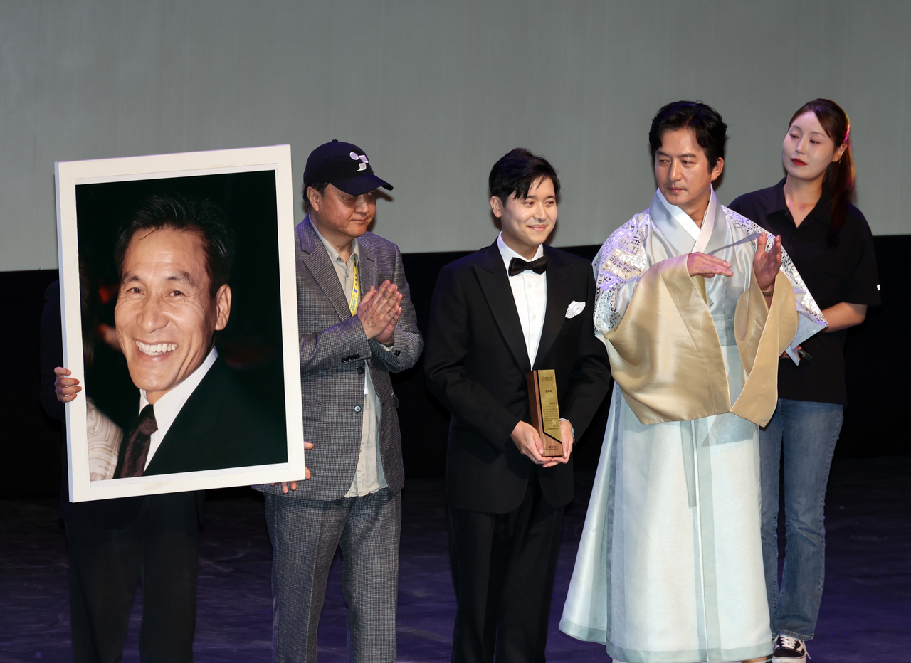 Philip Ahn (second from left) accepts the special achievement award on behalf of his late father Ahn Sung-ki at the opening ceremony of the 27th Jeonju International Film Festival in Jeonju on Wednesday. (Yonhap)