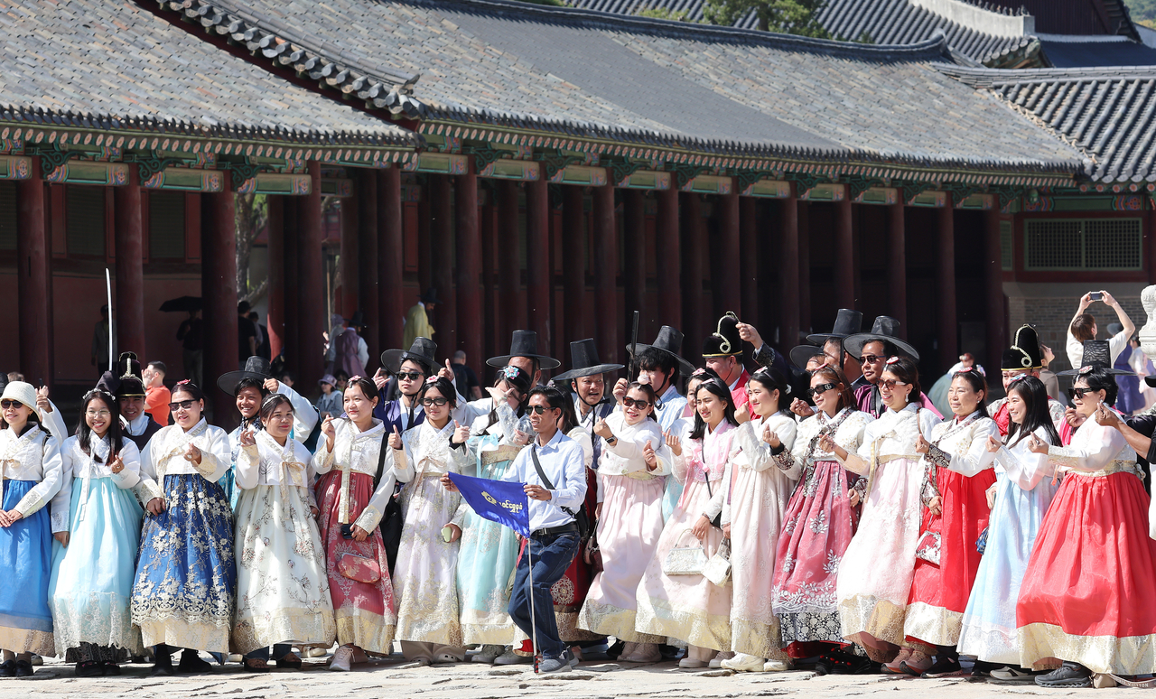 지난 16일 한복을 입고 서울 경복궁을 찾은 관광객들이 기념 촬영을 하고 있다. [연합]