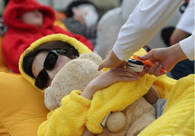 A participant sleeps as organizers collect sleep data during the Hangang Nap Competition at Yeouido Hangang Park on Saturday. (Yonhap)