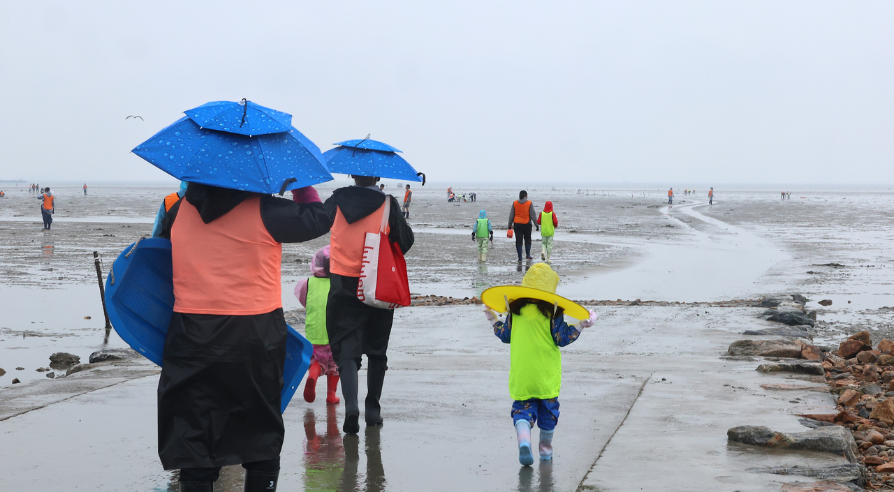 Visitors explore the tidal flats at Masian Beach on Yeongjongdo, Incheon, Sunday. (Yonhap)