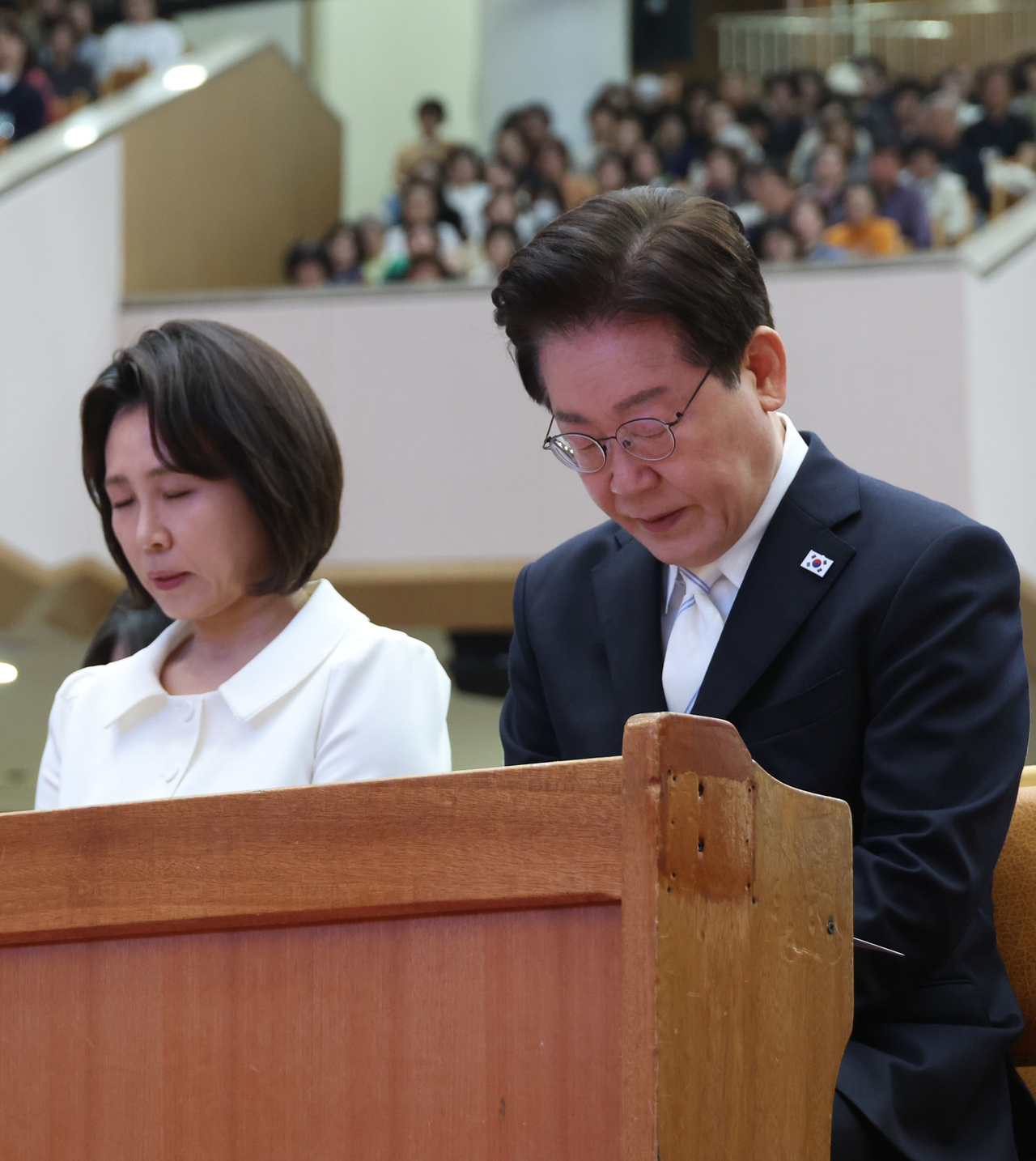 President Lee Jae Myung (right) and first lady Kim Hea Kyung pray during an Easter service at the Yoido Full Gospel Church in Seoul on April 5.  (Yonhap)