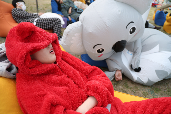 Participants wearing costumes sleep during the Hangang Nap Competition at Yeouido Hangang Park in Seoul on Saturday. (Yonhap)