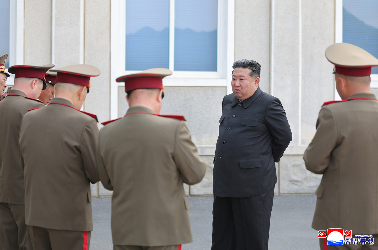 North Korean leader Kim Jong-un is seen speaking with military officials in an unrelated photograph released by the Korean Central News Agency on April 26. (Yonhap)