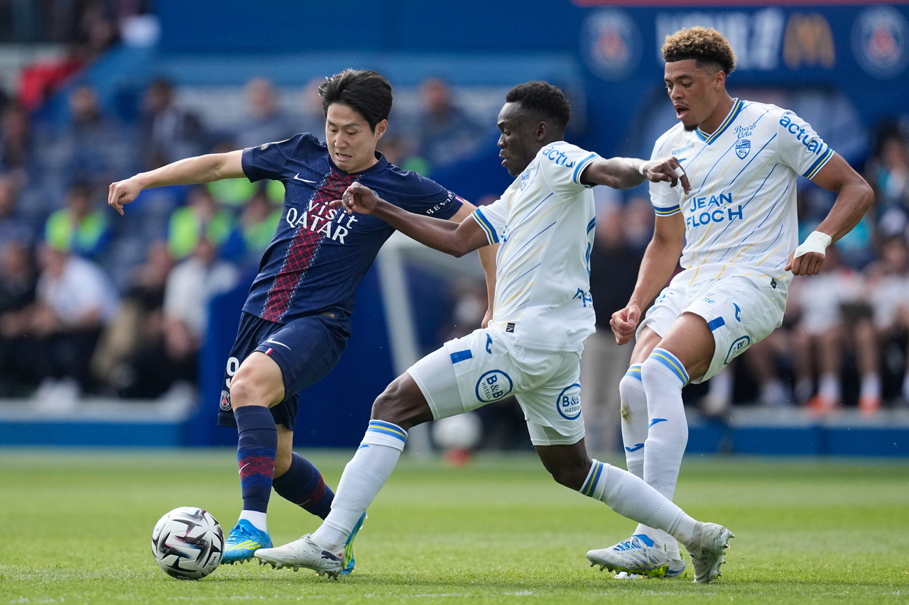 PSG’s Lee Kang-in (left) and Lorient’s Arthur Avom (center) vie for the ball, in Paris, France, Saturday. (AP-Yonhap)