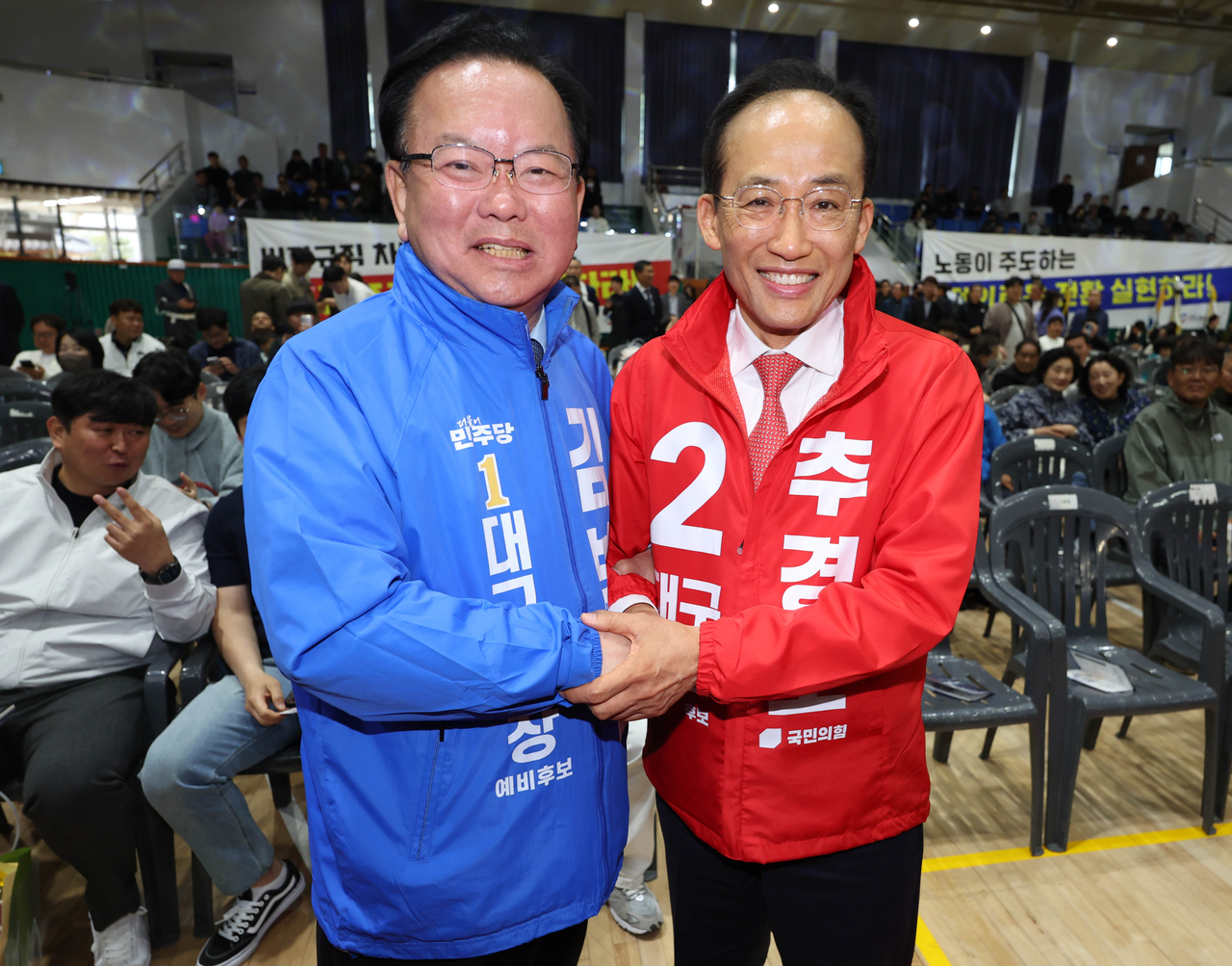 Daegu mayoral candidates, Kim Boo-kyum (left) of the Democratic Party and Choo Kyung-ho of the People Power Party, pose for a photo in a Labor Day rally in Daegu on Friday. (Yonhap)