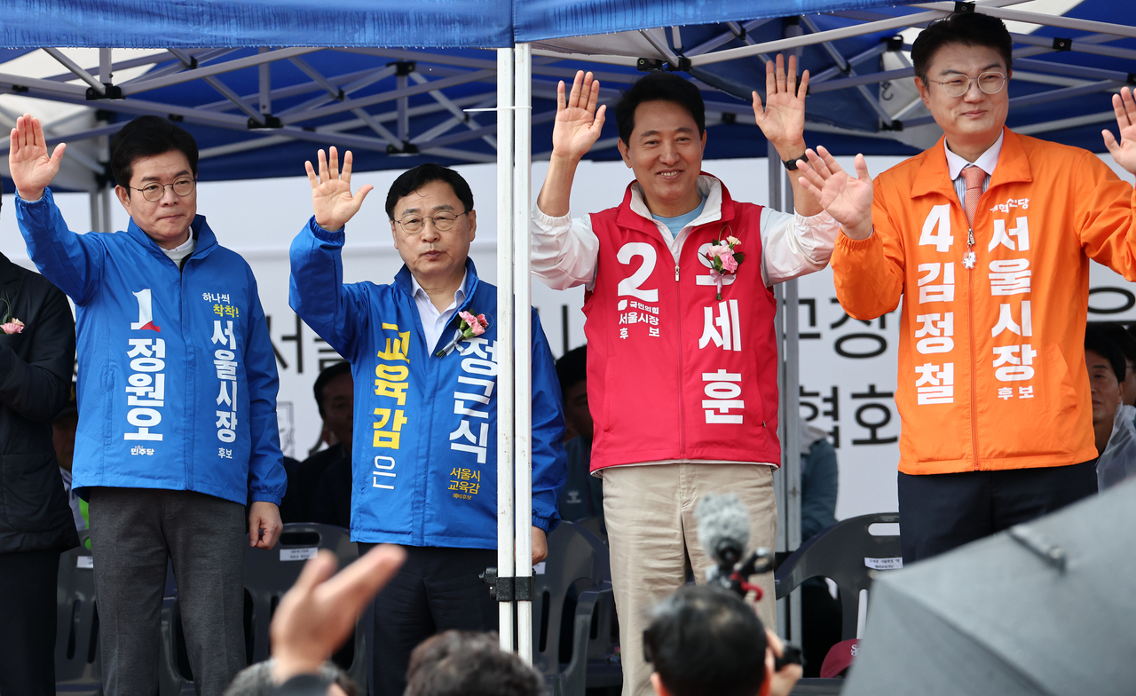 Democratic Party's Seoul mayoral candidate Chong Won-o (from left), Seoul education superintendent candidate Jung Keun-sik, Seoul mayor Oh Se-hoon and Reform Party's Seoul mayoral candidate Kim Jung-chul wave hands during a sports event held in Hyochang Park on Sunday. (Yonhap)