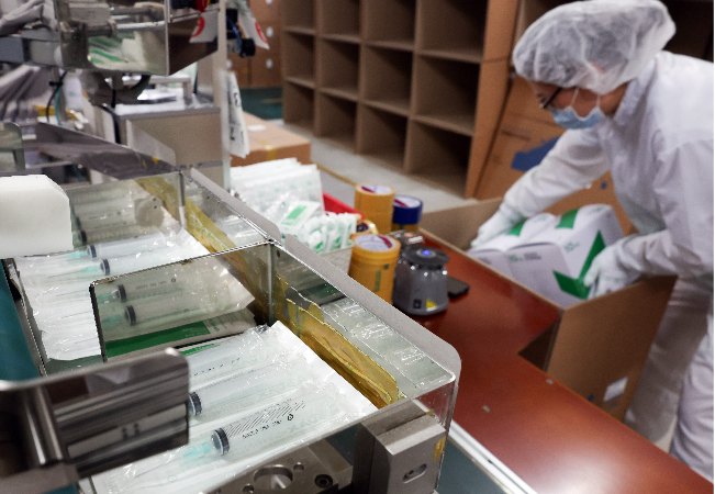A worker packs syringes at a vaccine manufacturer in Ansan, Gyeonggi Province, on April 15. (Yonhap)