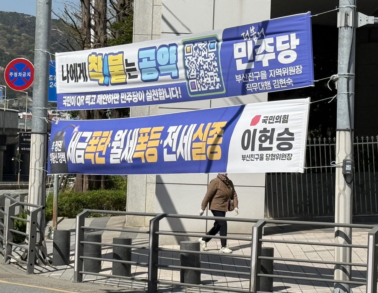 Political banners of the ruling Democratic Party of Korea (top) and main opposition People Power Party hang along a street in Busan on April 8. (Yonhap)
