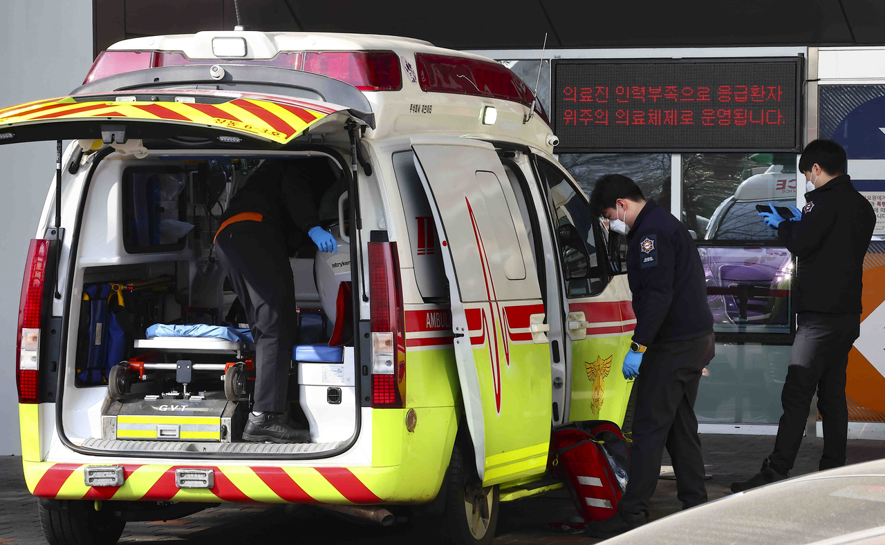 Paramedics are seen outside the emergency room of a university hospital in Seoul on Feb. 25. (Newsis)