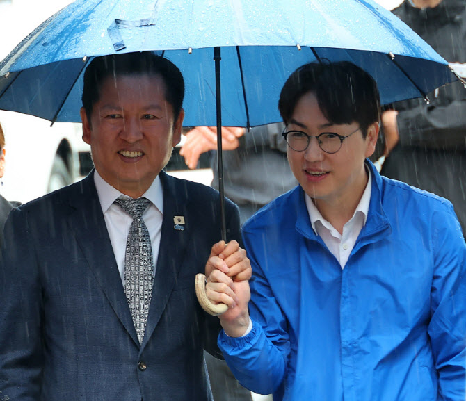 Jung Chung-rae, leader of the Democratic Party of Korea, walks alongside Ha Jung-woo, who is running in the parliamentary by-election for Busan’s Buk-gap, at Gupo Market in Buk-gu, Busan, on Sunday morning. (Yonhap)
