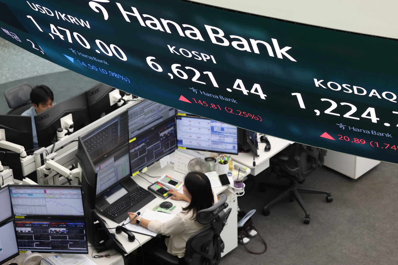 A display board hanging above the workstations at Hana Bank’s headquarters dealing room in Jung-gu, Seoul shows the won-dollar exchange rate and major stock indices. on April 27. (Yonhap)