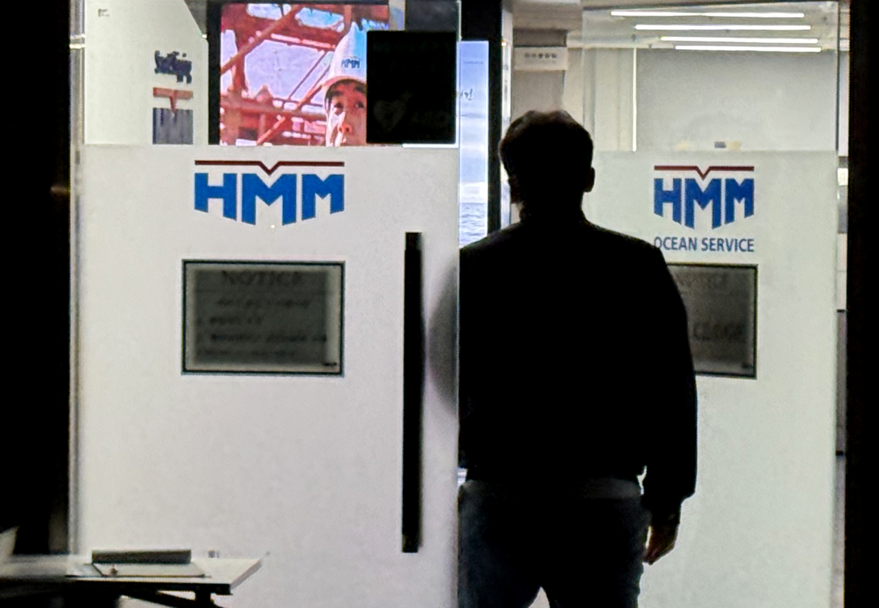 Employees move in and out of HMM’s vessel operations control center in Jung-gu, Busan, on Tuesday afternoon, two days after a fire broke out following an explosion on an HMM-operated vessel anchored in the Strait of Hormuz. (Yonhap)