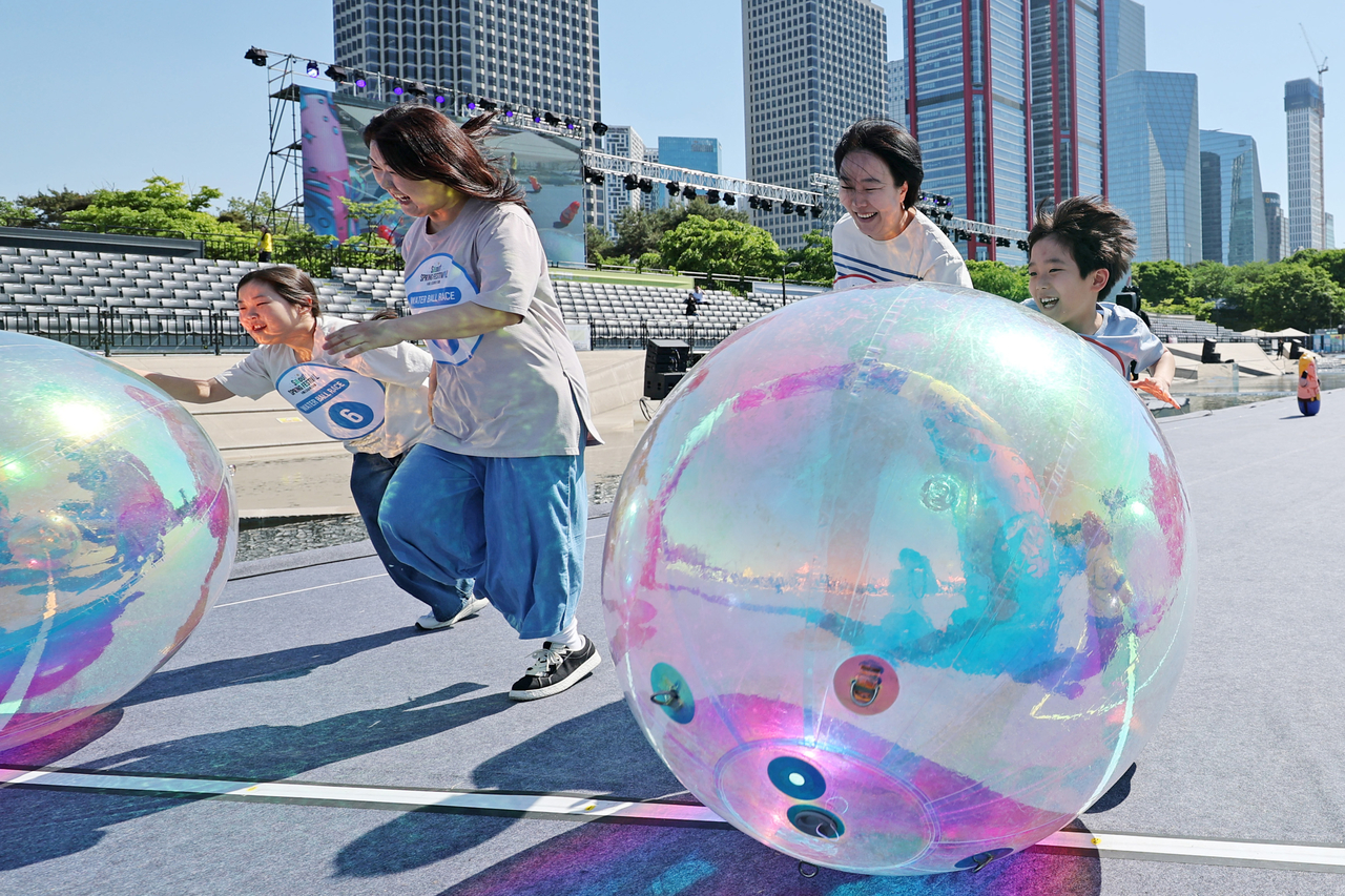 Participants compete in the "Water Ball Race," a special event at the 2026 Seoul Spring Festival in Seoul on Children's Day. (Yonhap)
