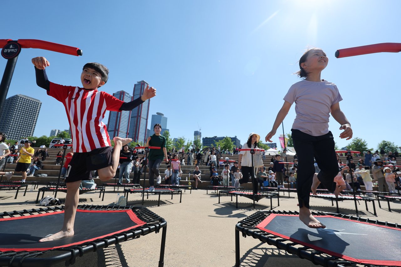 Children bounce on trampolines at the 2026 Seoul Spring Festival held at Yeouido Hangang Park in Seoul on Children's Day. (Yonhap)
